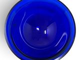 a blue glass bowl sitting on a white surface