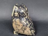 an owl figurine sitting on top of a black surface