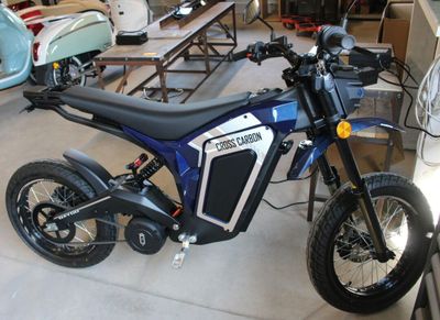une moto bleue et noire garée dans un garage