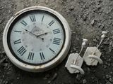 a clock that is sitting on the ground next to some wires