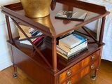 a small table with a lamp on top of it next to a bed