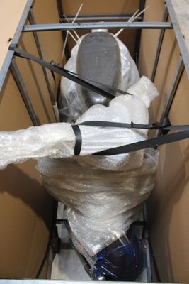 une boîte contenant des toilettes et emballée dans du plastique