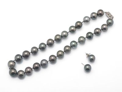 gros plan d'un collier et de boucles d'oreilles sur une surface blanche