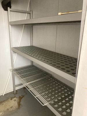 une étagère métallique dans le coin d'une pièce