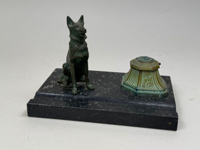 statue of a dog sitting on a base next to a lamp