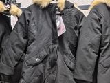 many coats hanging on a rack in a store