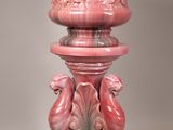 a pink vase sitting on top of a pedestal