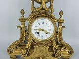 une horloge en or posée sur une table blanche