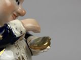 a figurine of a man holding a coin in his hand