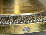 an image of a close up of a brass plate with a diamond on it