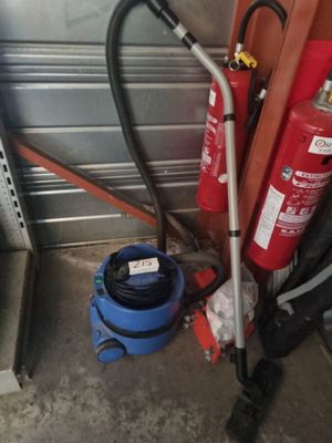 un extincteur rouge à côté d'un seau bleu
