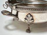 a silver bowl with a lid on a white table