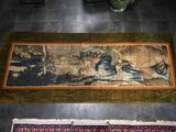 two rugs on the floor with a painting on them