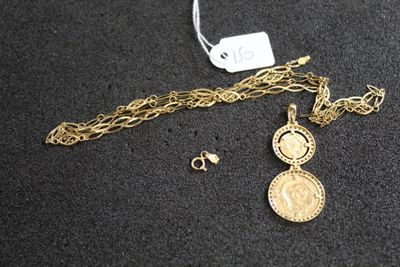 Gros plan sur un collier en or sur lequel se trouve une pièce de monnaie