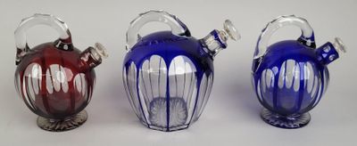 trois vases en verre de couleurs différentes posés sur une table