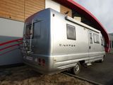 a silver camper that is parked in front of a building