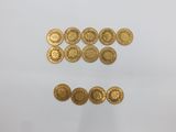 a close up of a pile of gold coins sitting on top of a white surface
