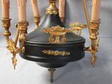 a black and gold chandelier with candles on it