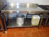 une table en métal sur laquelle est posé un faitout, dans une cuisine