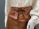 brown leather skirt with belt and buttons on a mannequin