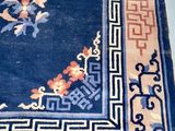 a blue area rug with oriental designs on it