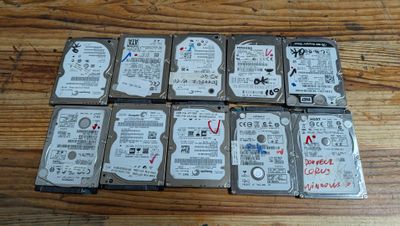 Plusieurs disques durs sont empilés les uns sur les autres sur une table en bois