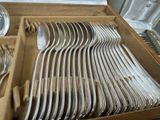 a lot of silver spoons and forks in a box