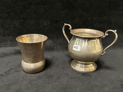 une paire de tasses plaquées argent et une tasse plaquée argent sur fond noir