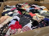 une boîte en carton remplie de nombreux vêtements dans un entrepôt
