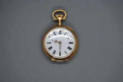 une montre de poche en or avec des chiffres romains sur le cadran