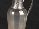 an antique silver plated glass pitcher on a black background
