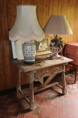 a table with a lamp on top of it next to a chair