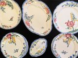 six assiettes aux motifs variés, disposées sur une table noire