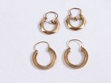 three pairs of gold hoop earrings on a white surface