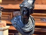 une statue représentant une femme portant un casque, posée sur une table