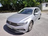La Volkswagen Passat est garée sur un parking, avec des arbres en arrière-plan.