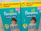 deux boîtes de couches Pampers Baby Dry posées sur une table