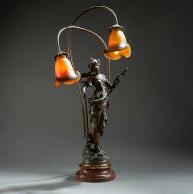 une image représentant une lampe surmontée d'une statue