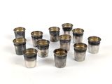 Plusieurs verres à shot sont disposés en cercle sur une surface blanche