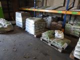 many bags of food sitting on pallets in a warehouse