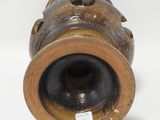 a brown vase that is sitting on a white surface