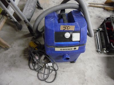 un aspirateur bleu posé par terre à côté d'un tas d'outils