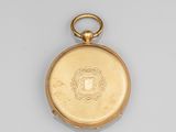 a close up of a gold pocket watch on a white surface