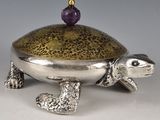 silver and gold turtle box with amethorate on top