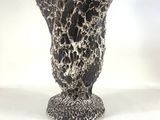 a black and white vase sitting on a white surface