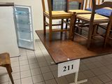several chairs and a table in a room with a refrigerator