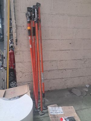 une pile de skis et de bâtons de ski près d'un mur
