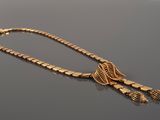 a close up of a gold necklace on a black surface
