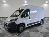 la camionnette blanche est garée sur un sol carrelé en damier
