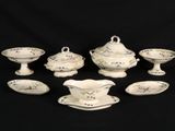 a group of porcelain dishes and saucers on a black background